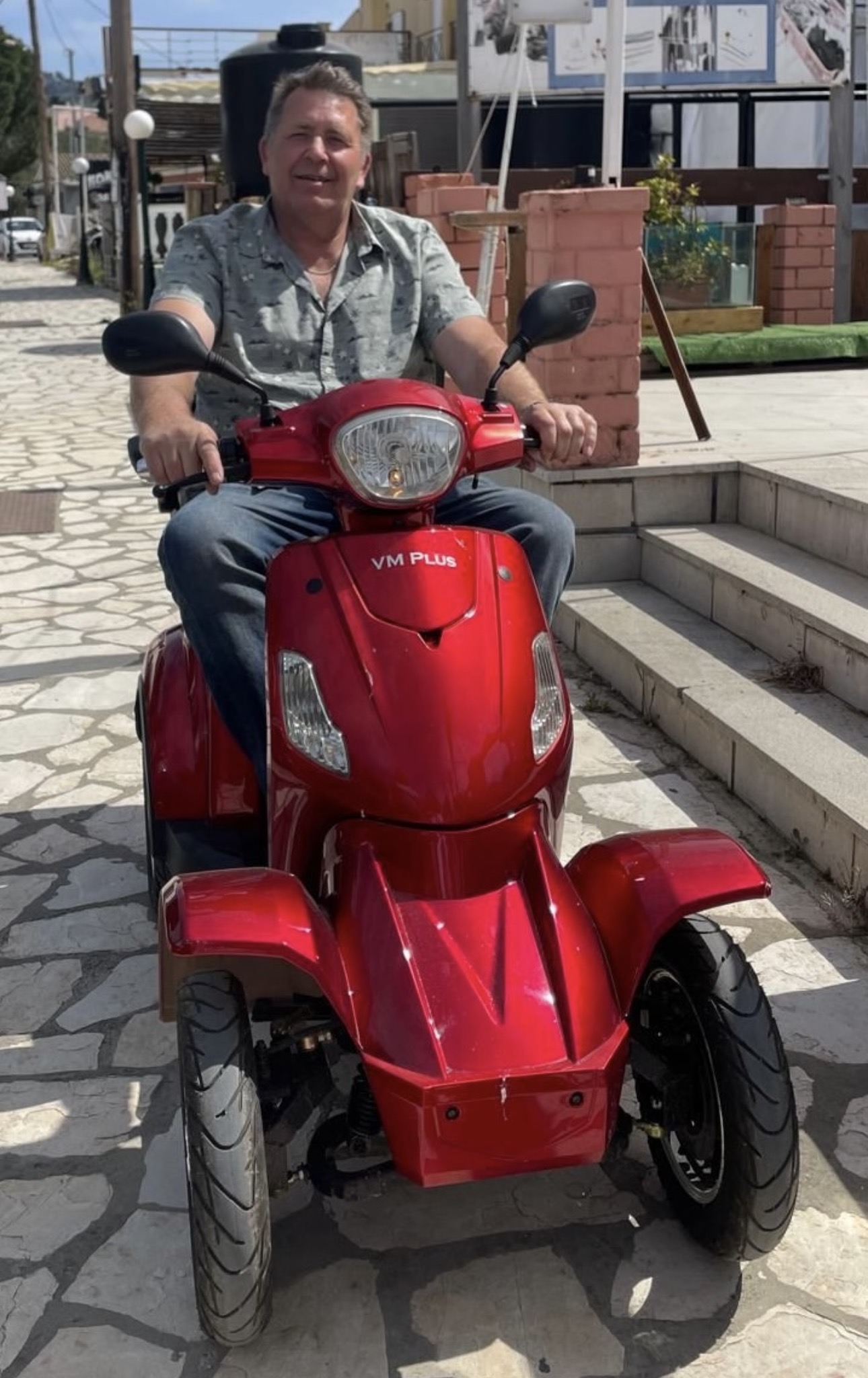 Lee demonstrating a red mobility scooter in Messonghi