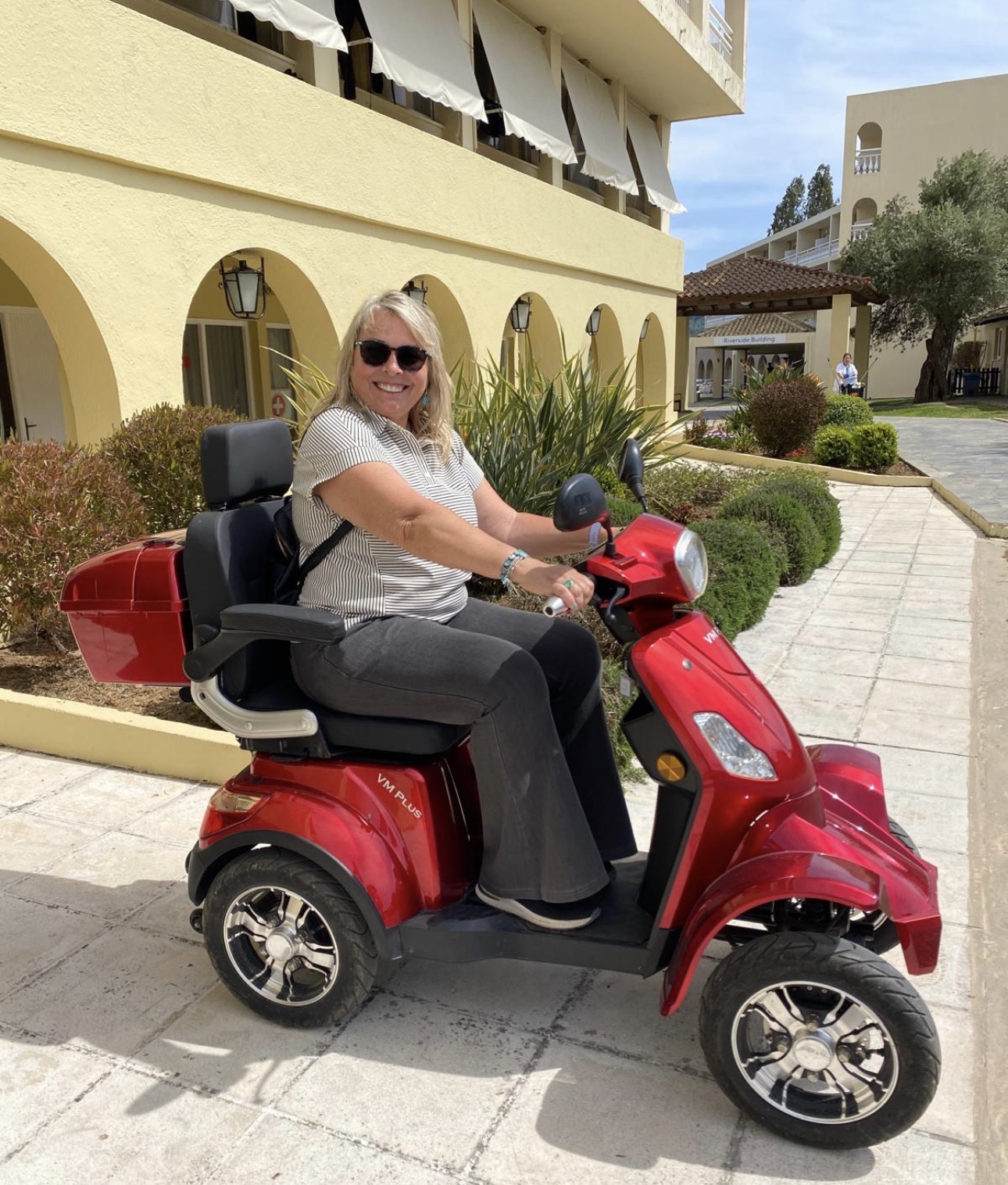 A guest enjoying a red mobility scooter at a Corfu hotel