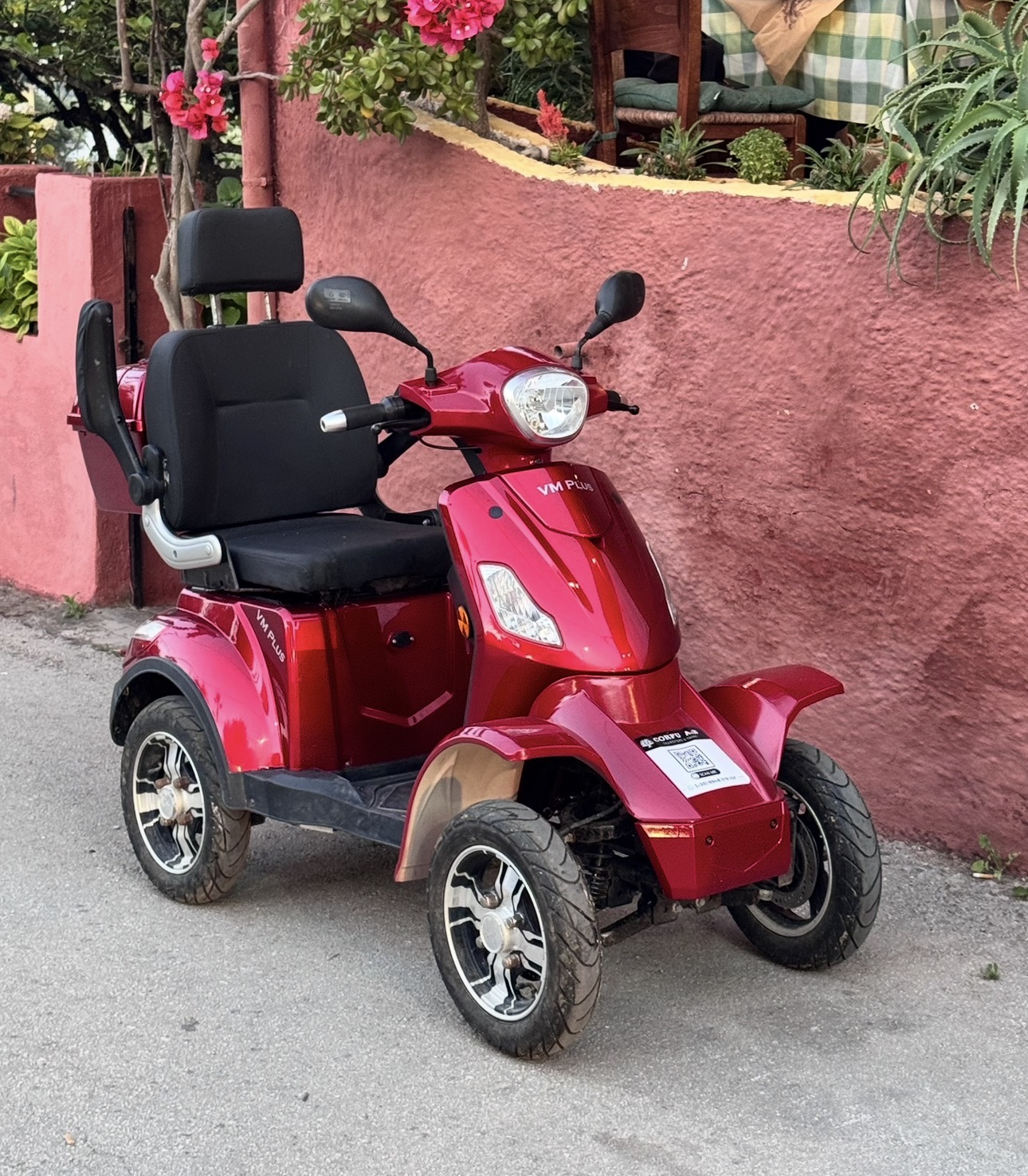 A red four-wheel mobility scooter available to hire in Messonghi